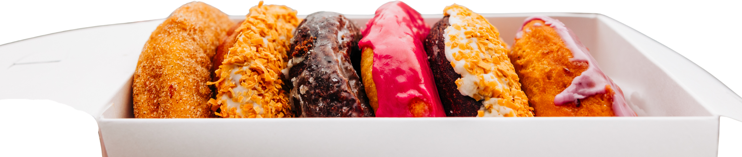 A hand holding an open box of Holy Donut donuts